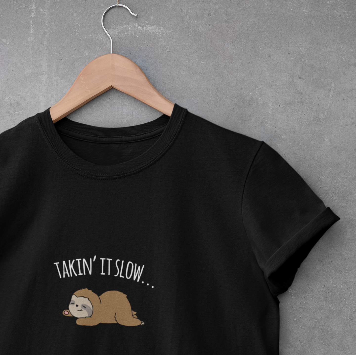 brown sleeping lazy sloth pun advice to take it slow in white text on black hanging t-shirt.