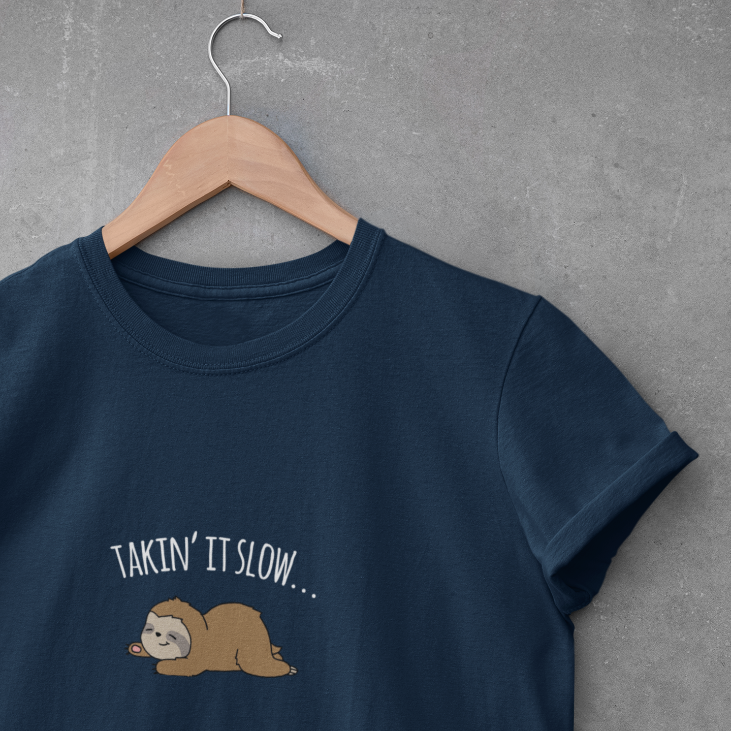 brown sleeping lazy sloth pun advice to take it slow in white text on navy blue hanging t-shirt.