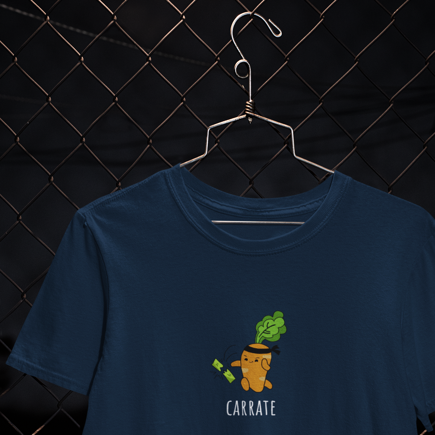 orange animated carrot with black headband chopping green leafy vegetables with karate chop on navy blue t-shirt.